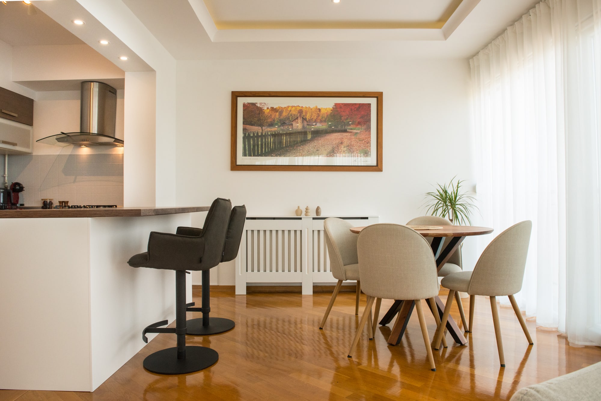 Open kitchen with breakfast bar beside a four-seat dining table