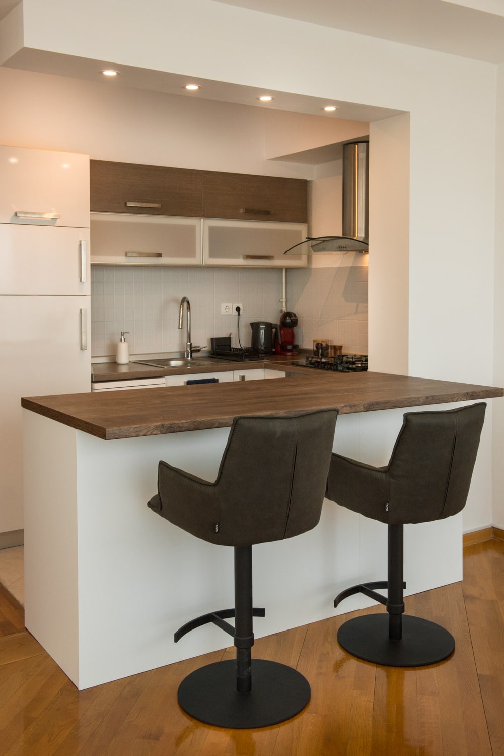 Fully equipped kitchen with breakfast bar, two stools and modern appliances